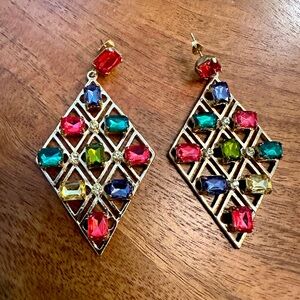 Fashion jewelry. Gold colored earrings with square colored stones.